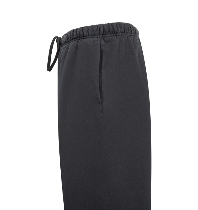 Image 3 of 4 - BLACK - FEAR OF GOD ESSENTIALS Heavy Fleece Lounge Sweatpant featuring 520gsm heavy fleece treated with a pigment dye, wide-leg silhouette, bold Essentials script logo on the leg, encased elastic waistband with elongated drawcords, side seam pockets and a Fear of God Essentials rubberized label stitched at the center front. 100% cotton.