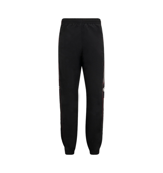 Image 1 of 3 - BLACK - MARTINE ROSE Hockey Track Pants featuring loose fit, elasticated drawstring waistband, two side zip pockets, contrasting piping, embroidered logo at side and elasticated cuffs. 100% polyamide.