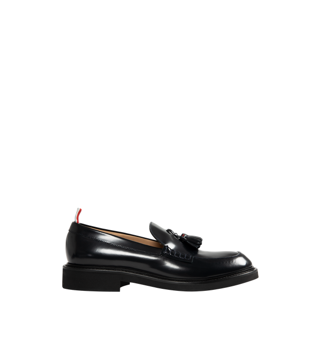 Image 1 of 4 - NAVY - THOM BROWNE Spazzolato Leather Tassle Loafer featuring classic penny loafers with red, white, and blue trim at the tassels, slip on and signature striped grosgrain loop tabs at heels 100% calf leather. Sole: 100% rubber. Lining: 100% calf leather. Made in Italy.