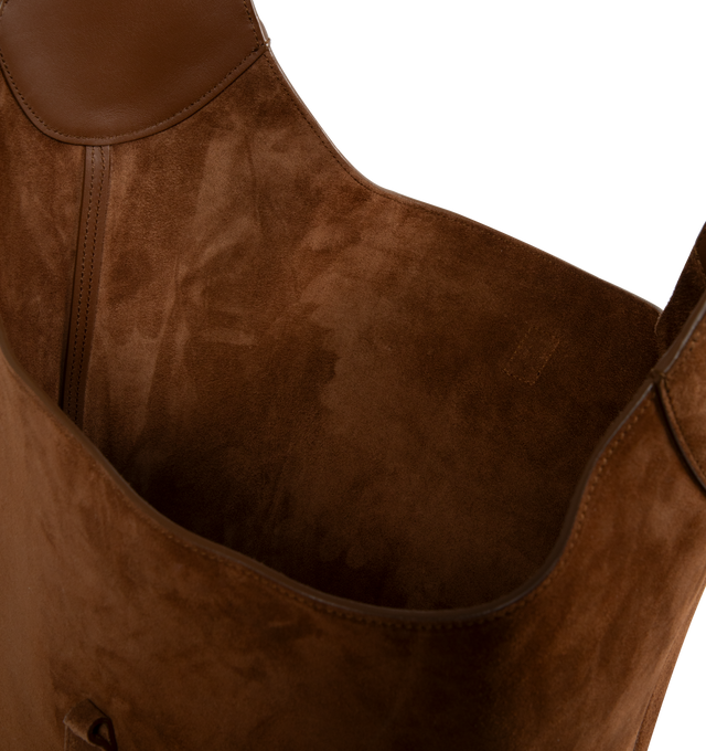 Image 3 of 3 - BROWN - Saint Laurent hobo bucket version of the iconic LE 5  7 in suede with leather lining, defined by its leather tab closure decorated with the CASSANDRE. Spacious and lined in tonal leather, it features one main compartment with an inner zip pocket. An adjustable strap allows for bespoke carry options. Featuring bronze-toned hardware, four metal feet. Measures 10.217.3" x 12.6" x 1.2" with 13" handle drop. Made in Italy.