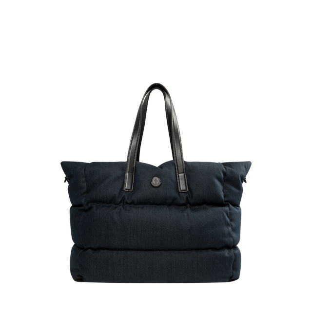 Image 1 of 3 - BLUE - Moncler Mens New Caradoc Tote Bag is crafted from denim with signature boudin quilting inspired by Moncler puffer jackets. Features leather trim and handles, adjustable and detachable shoulder strap, clasp closure, interior zip pocket, metal logo, and down-filled construction. Exterior: 75% Cotton, 24% Polyester, 1% Elastane/Spandex; Lining: 100% Cotton; Padding: 90% Down, 10% Feather; Leather Inserts: Calf Leather. Dimensions: 45cm L x 35cm H x 20cm D. Made in Romania.
