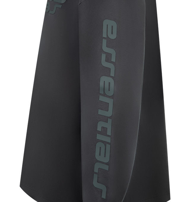 Image 3 of 3 - BLACK - FEAR OF GOD ESSENTIALS 90s Long Sleeve Tee featuring an oversized 90s-inspired silhouette, exaggerated proportions with dropped shoulders for a relaxed drape that tapers to rib-knit cuffs, HD print application of the Fear of God Essentials on front, the Essentials logos on the sleeves and signature rubberized Fear of God Essentials label at the collar. 100% cotton jersey.