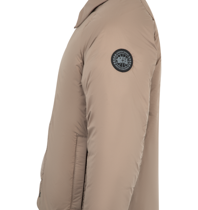 Image 3 of 3 - BROWN - CANADA GOOSE Lodge Coach Jacket featuring a pointed collar, packable into interior zip pocket, snap front closure, two exterior zippered pockets and two interior pockets: one drop-in pocket, one zippered security pocket. 100% nylon. Made in Canada.