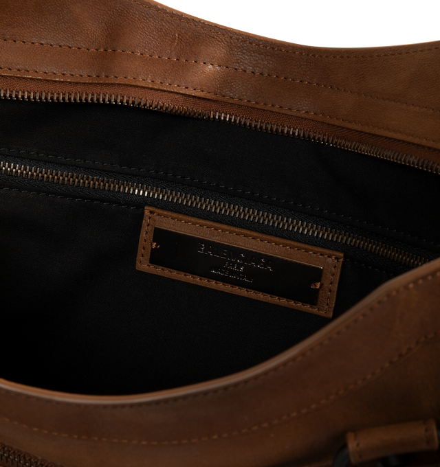 Image 3 of 3 - BROWN - Balenciaga Men's Le City Bag Large is crafted from vintage goatskin and features the house's iconic relaxed silhouette with two hand-braided handles detailed with waxed cord. Designed for hand or crossbody carry, this designer bag features an adjustable and removable shoulder strap with shoulder pad, brass hardware, a double-sided zip closure with long tails and knotted leather puller, front zipped pocket, interior zipped pocket, removable mirror with tone-on-tone Balenciaga logo, and