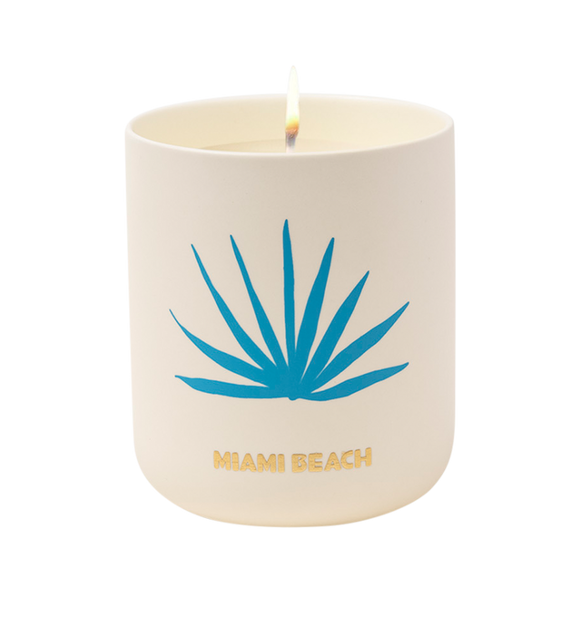 Image 2 of 5 - MULTI - Assouline Miami Beach - Travel From Home Candle. Its an everlasting summer with sun-drenched notes of bergamot, juicy peach, and smooth pistachio that capture the essence of sun-kissed beaches and lively summer beach parties. A heart of blooming florals intertwines with the balmy essence of sandalwood, creating a captivating aroma that embodies the spirited atmosphere and warmth of Miami's sultry nights. Material: Ceramic Vessel. Wax Family: Soy, Coco, Paraffin Blend. Approximate Bur