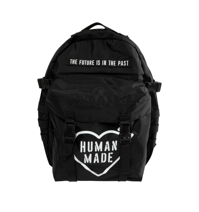 Image 1 of 3 - BLACK - Human Made Military Backpack is crafted from lightweight nylon Oxford fabric and features a military-inspired silhouette with stencil-style graphics and modular attachment functionality. Designed with a front flap pocket with buckle strap closure, a cushioned sleeve for a laptop or tablet, mesh-padded back panel, adjustable waist belt, and B4-sized storage capacity for everyday versatility. Main Material: Shell: 100% Nylon. Lining: 100% Polyester. Dimensions: 44 cm H x 32 cm W x 11 cm