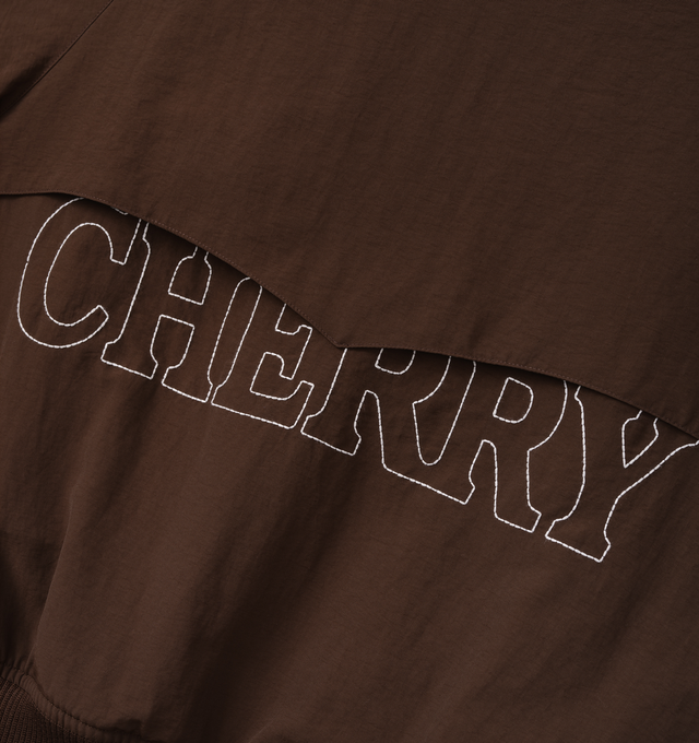 Image 4 of 7 - BROWN - Cherry LA Nylon Championship Jacket is crafted from nylon and features a regular-fit silhouette, a front nickel zip closure, and rib-knit cuffs and hem. Designed with a brushed cotton lining, welt pockets with hidden snap closures, and embroidered detailing at the neck and center back, this lightweight jacket draws inspiration from classic championship styles with a contemporary finish. Main Material: Nylon. Lining: Brushed Cotton. Made in Los Angeles, USA.