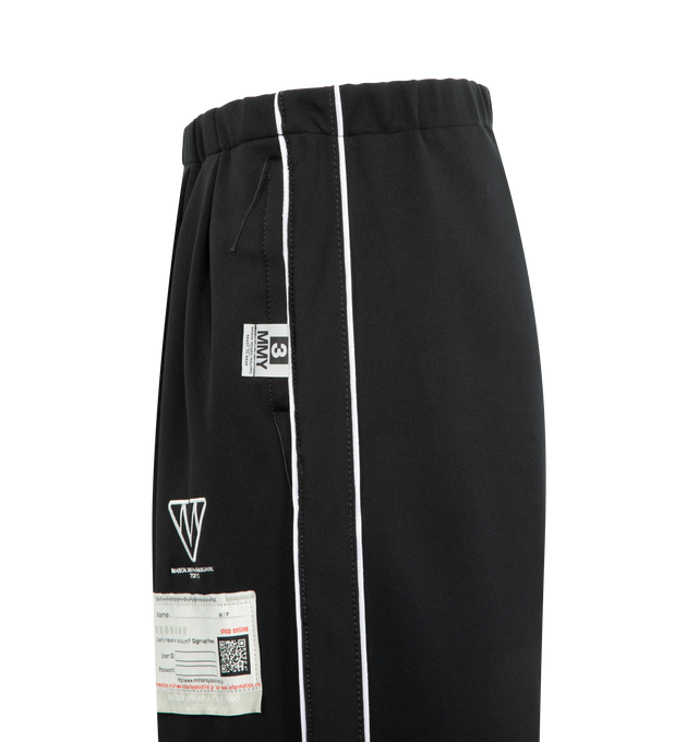 Image 3 of 3 - BLACK - Maison Mihara Yasuhiro Men's Amateur Sewn Track Pants feature an elastic waistband, signature embroidered logo detailing, side striped trim, side pockets, and a back pocket for a sporty yet elevated look. These designer track pants combine everyday comfort with the brand's contemporary aesthetic, making them a versatile choice for casual and streetwear styling. Material: 100% Polyester.