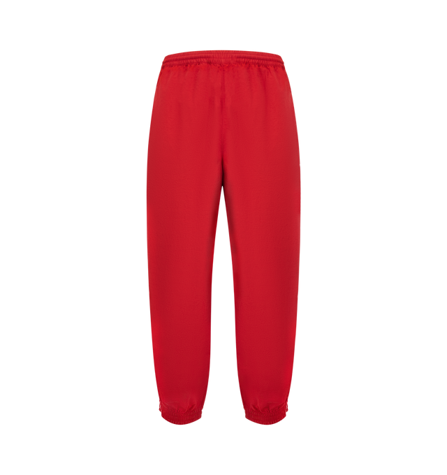Image 2 of 3 - RED - WILLY CHAVARRIA Bad Boy Track Pants featuring elastic waistband with interior drawstring, side seam pockets, elastic hem and lightweight ripstop fabric with embroidered logo on left side. 100% nylon. Made in USA.