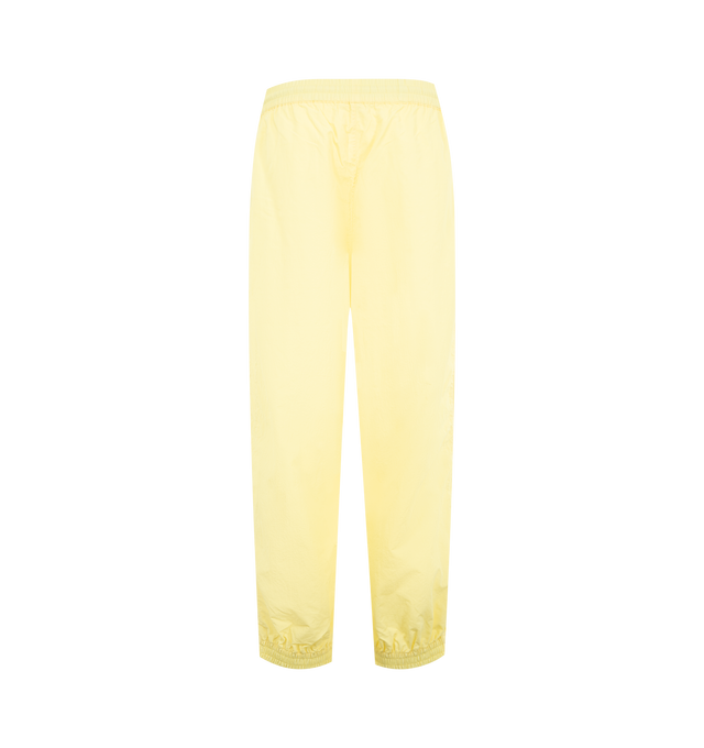 Image 1 of 3 - YELLOW - WILLY CHAVARRIA Bad Boy Track Pant featuring a relaxed, easy fit, side pockets, elastic waistband and hems, lightweight, stacked double CHAVARRIA logos at the left pocket and double stripes down legs. 100% nylon.