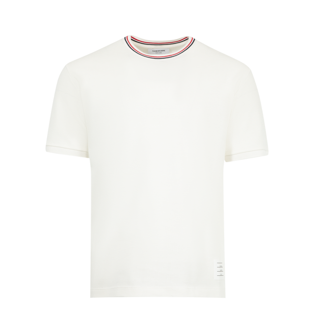 Image 1 of 3 - WHITE - THOM BROWNE Waffle Rib Cuff Tee featuring Thom Browne emblems at the hem, side vents, and collar, crew neck, short sleeves, name tag applique, buttoned side vents with signature striped grosgrain trim, dropped back hem and signature striped grosgrain loop tab. 100% cotton. Made in Italy.