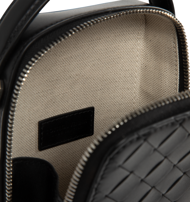 Image 3 of 3 - BLACK - BOTTEGA VENETA Getaway Phone Pouch featuring intrecciato calfskin leather, handle and adjustable cross-body strap, one main compartment, one flat inside pocket, leather gussets preventing items to fall from the sides and zip closure. Calfskin. Lining: canvas. 7.5 x 4.3 x 1.6. Made in Italy.