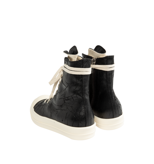 Image 3 of 5 - BLACK - Rick Owens DRKSHDW Men's Sneaks are crafted from 13 oz Megacrust Japanese denim and feature an above-ankle silhouette with eight eyelets, lace-up fastening, an interior ankle zipper, toe caps, and signature shark-tooth soles. Finished with a distinctive Megacrust treatment, the denim is overdyed black, wax-coated, and layered with black foil that naturally cracks and peels over time, creating a uniquely worn appearance with continued wear. Main Material: Upper 100% Cotton. Toe: 70% Po