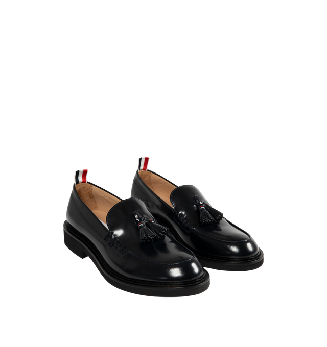 Image 2 of 4 - NAVY - THOM BROWNE Spazzolato Leather Tassle Loafer featuring classic penny loafers with red, white, and blue trim at the tassels, slip on and signature striped grosgrain loop tabs at heels 100% calf leather. Sole: 100% rubber. Lining: 100% calf leather. Made in Italy.