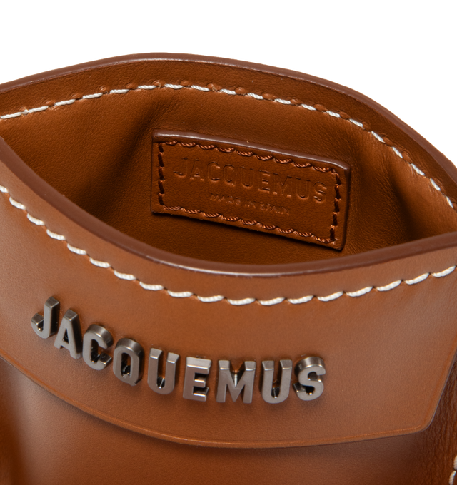 Image 3 of 3 - BROWN - JACQUEMUS Le Porte Poche Meunier featuring fixed shoulder strap, logo hardware at face, three card slots at back face, zip pocket at back face, patch pocket, logo-engraved gunmetal-tone hardware and contrast stitching. H5.75 x W4.75 in. 100% leather. Made in Spain. 