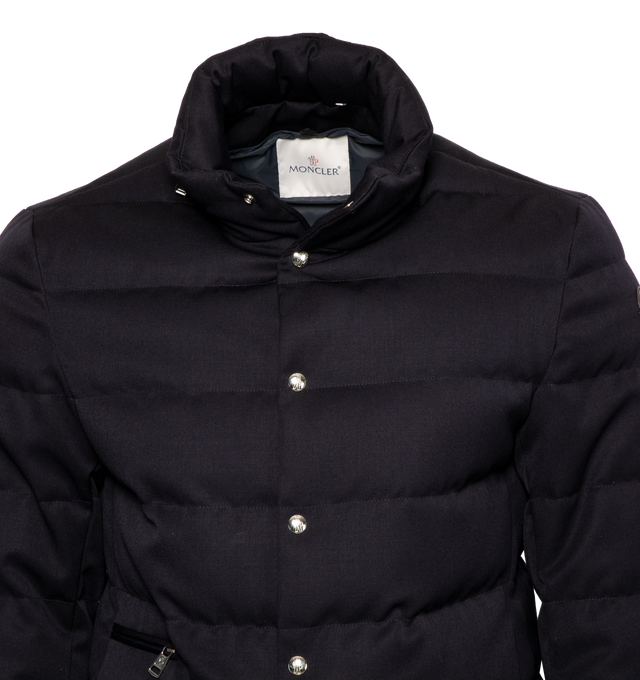 Image 5 of 5 - NAVY - MONCLER Bess Short Down Jacket featuring nylon lger lining, down-filled, pull-out, adjustable rainwear hood with elastic drawstring fastening and snap buttons, contrasting-colored interior piping, ribbed knit collar, inner front bottom with tricolored detailing, zipper and snap button closure, zipped external and internal pockets and leather logo. 100% virgin wool. Lining: 100% polyamide/nylon. Padding: 90% down, 10% feather. 