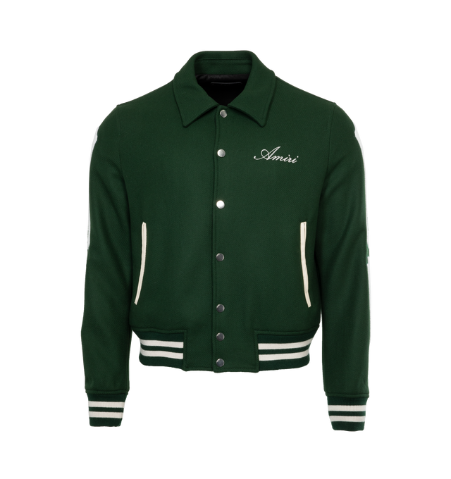 Image 1 of 3 - GREEN - AMIRI BONES JACKET is a wool varsity-style bomber jacket embroidered with an Amiri logo on the chest and bone detailing on the sleeves in white. This jacket also has a point collar, long sleeves, ribbed cuffs, ribbed hem, and a front snap closure. 75% wool, 25% nylon. Lining: 100% viscose Trim: 98% wool, 2% elastane. 