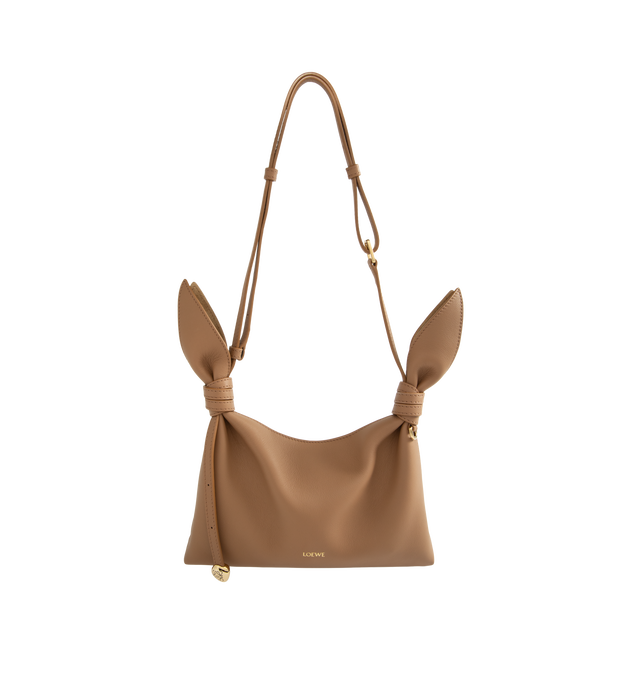 Image 1 of 3 - BROWN - Loewe Women's Mini Scarf Bag is crafted from suede and features the collection's signature silhouette formed by two panels elegantly tied together with a leather knot, finished with a distorted Pebble detail. Designed for hand, shoulder, or crossbody carry, this compact style is equipped with an adjustable leather strap, magnetic closure, nappa lining, engraved Anagram Pebble hardware, and embossed 'LOEWE' branding. Main Material: Suede. Lining: Nappa Leather. Dimensions: 24.5 x 14.5
