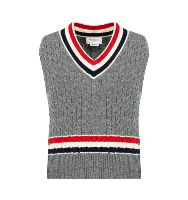 Image 1 of 2 - GREY - Thom Browne Mens Wool V-Neck Vest is crafted from cashmere and features a classic V-neck, signature RWB stripe detailing at the neckline and hem, buttoned side vents, buttoned rib-knit trim with signature striped grosgrain accents, and the signature striped grosgrain loop tab at the back. This designer cashmere sweater vest combines traditional Aran cable knit construction with iconic Thom Browne detailing for elevated everyday layering. Main Material: Wool. Made in Italy.