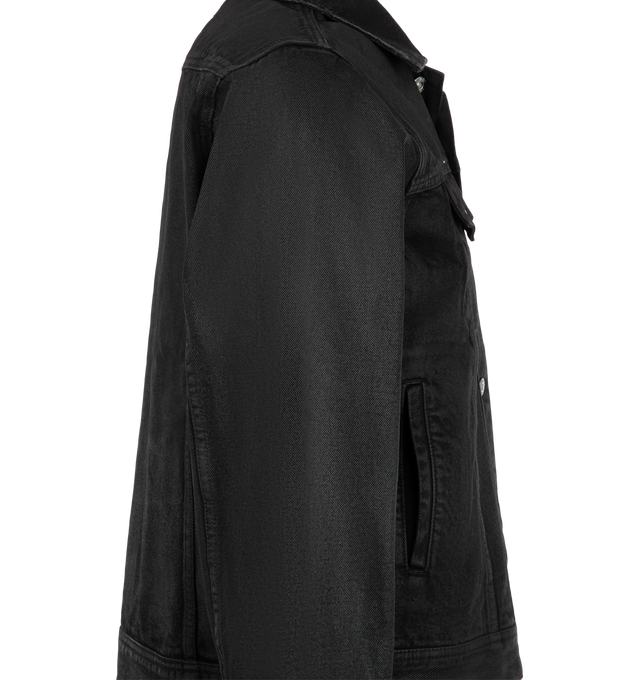 Image 3 of 3 - BLACK - Midnight Rodeo Waxed Essential Denim Trucker is crafted from cotton denim and features a structured trucker silhouette with a waxed coating that creates a dry luster inspired by mesquite and iron-clay desert tones. Designed with a spread collar, front button closure, chest flap pockets, front welt pockets, button cuffs, and adjustable button side tabs, this cropped jacket balances heritage workwear details with a modern, architectural shape. Main Material: Cotton.