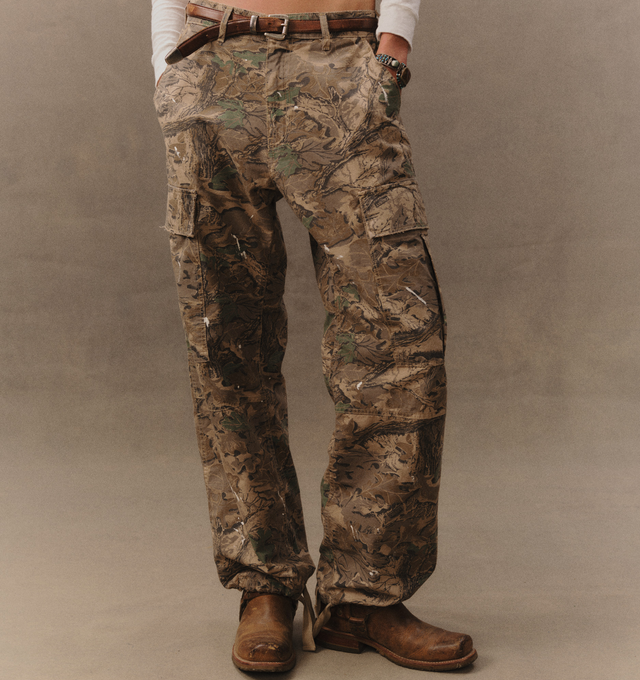 Image 5 of 7 - GREEN - Cherry LA Wide Leg Cargo Pants are crafted from custom camouflage cotton ripstop and feature a wide-leg silhouette with utility-inspired cargo pocket detailing. Designed with hidden snap closures at the pockets, paint splatter accents, and distressed finishes throughout, this statement style combines military influences with Cherry LA's signature lived-in aesthetic. Main Material: Custom Camouflage Cotton Ripstop. Fit: Wide Leg. Pockets: Cargo Pockets with Hidden Snap Closures. Detail