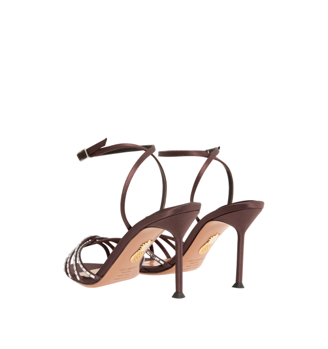 Image 3 of 4 - BROWN - AQUAZZURA Tell Me Crystal Sandal 85 featuring adjustable buckle closure, gemstones that trace the caged design framing the toes, slim stiletto mid heel, padded leather insole and signature logo detailing. Satin. 85mm heel. Made in Italy.