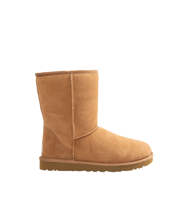 Image 1 of 4 - BROWN - UGG Men's Classic Short Boots are crafted from premium suede and feature the brand's iconic mid-calf silhouette with a soft sheepskin lining and cushioned footbed for signature warmth and comfort. These designer boots combine timeless style with lightweight cushioning and a durable outsole, making them an everyday cold-weather essential. Main Material: Suede. Lining: Sheepskin. Sole: Durable Rubber.