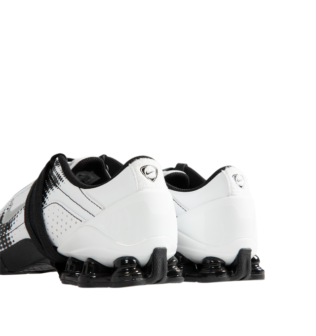 Image 3 of 5 - WHITE - Nike Women's Total 90 Shox Magia Sneakers feature a premium nubuck leather upper with oversized laces and printed graphic detailing, combining the iconic design of the Total 90 with a sleek, tonal finish. Inspired by early-2000s soccer style, these lifestyle sneakers pair signature Nike Shox cushioning with a durable rubber outsole for responsive comfort and everyday wear. Main Material: Nubuck Leather. Midsole: Nike Shox. Sole: Rubber.