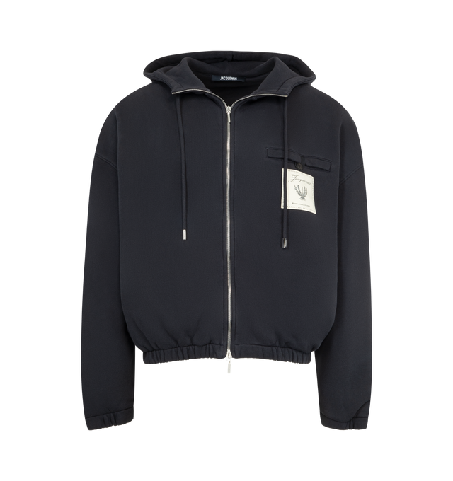 Image 1 of 3 - BLACK - JACQUEMUS Torneo Hoodie featuring rosemary label zipped hoodie, oversized fit, brushed cotton fleece, hood with drawstrings, square metal tips with engraving, drawstring hood with circle and square tips, double-sided zipper, buttoned welt pocket with "J" loop, embroidered Rosemary logo patch, side-seam pockets, elasticated cuffs and hem, embroidered logo patch on the back and fully lined. 100% cotton. Made in Portugal.
