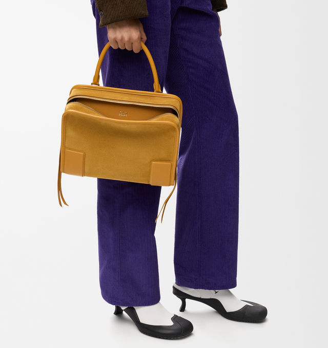 Image 2 of 16 - YELLOW - Loewe Women's Amazona 180 Medium Bag is crafted from suede and calf leather and features a relaxed silhouette with a single toron top handle, a concealed magnetic closure, and removable shoulder and crossbody straps. Designed with two compartments, an internal flat pocket, and a side D-ring for personalization, this versatile style can be carried by hand, over the shoulder, or crossbody. Suede lining and embossed LOEWE branding complete the design. Main Material: Suede/Calf Leather.