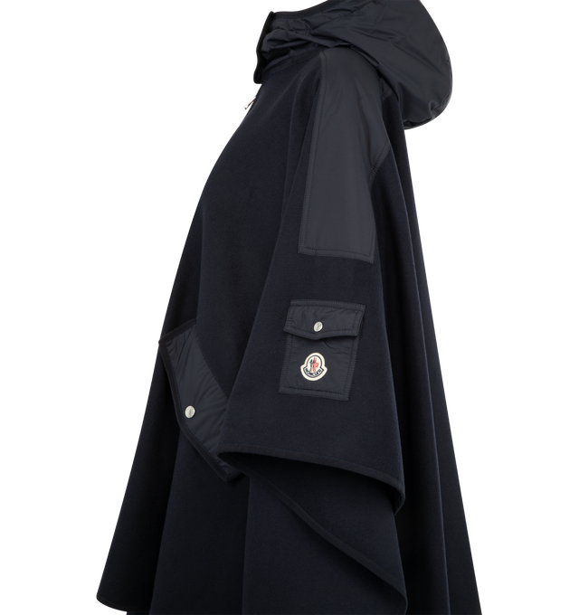 Image 3 of 3 - NAVY - MONCLER Cape featuring a two-way zip fastening, logo patch details one sleeve, hood and snap closure pockets. 75% virgin wool, 25% polyamide. Trim: 100% polyester.