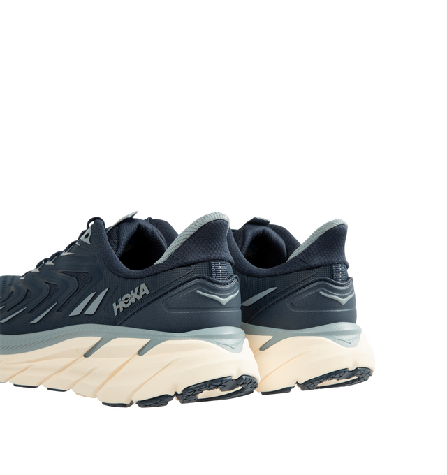 Image 3 of 5 - BLUE - Hoka Men's Clifton UTL is crafted with a breathable mesh upper and features raised PU-molded overlays that create a textured exoskeleton for added durability and support. Built on the brands popular Clifton 8 platform, this lifestyle sneaker is designed with reflective laces and webbing details, a plush CMEVA midsole, and a Durabrasion rubber outsole for everyday comfort and traction. Upper: Mesh with PU-Molded Overlays. Midsole: CMEVA. Outsole: Durabrasion Rubber. Details: Reflective