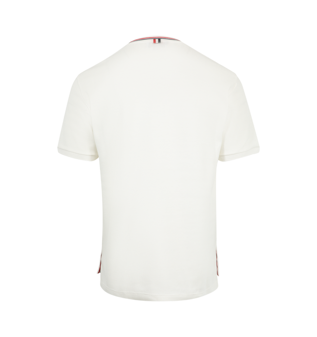 Image 2 of 3 - WHITE - THOM BROWNE Waffle Rib Cuff Tee featuring Thom Browne emblems at the hem, side vents, and collar, crew neck, short sleeves, name tag applique, buttoned side vents with signature striped grosgrain trim, dropped back hem and signature striped grosgrain loop tab. 100% cotton. Made in Italy.