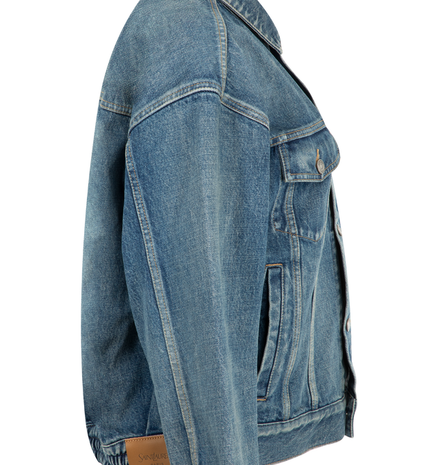 Image 3 of 3 - BLUE - Saint Laurent Womens Jean Jacket is crafted from certified cotton denim. Features a loose fit, button-front closure, pointed collar, buttoned flap chest pockets, front welt pockets, one-button cuffs, cotton lining, and embossed Saint Laurent Paris leather jacron. Main Material: 100% Cotton; Lining: Cotton. Made in Japan.
