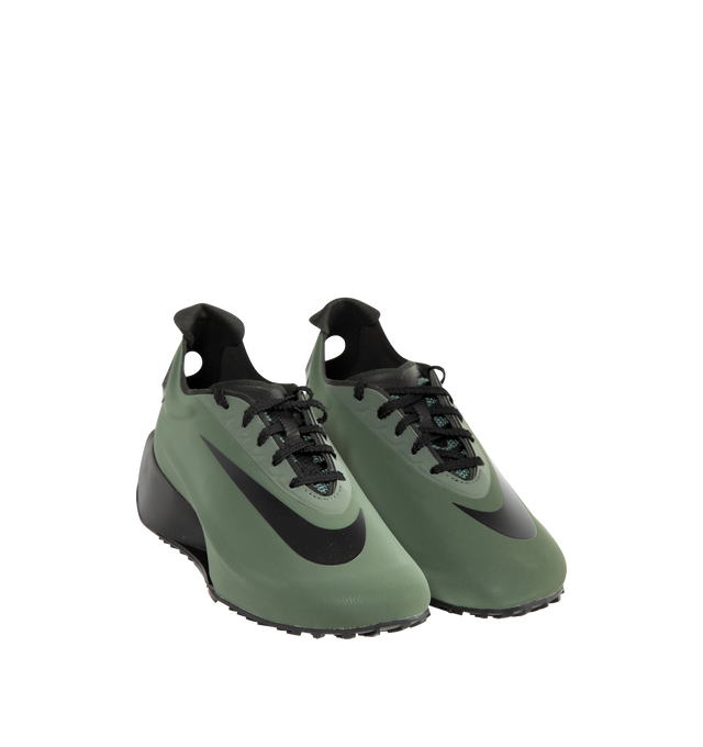 Image 2 of 5 - GREEN - Nike Women's First Sight Noir Sneakers are crafted from a sleek one-piece upper and feature a sculptural silhouette inspired by Nike's running heritage. Designed as the debut style in the First Sight collection, this fashion-forward sneaker is defined by a circular heel cutout, a thick angular foam midsole, and bold branding details that blend athletic performance with modern statement styling. Main Material: Synthetic Upper. Midsole: Soft Foam Cushioning. Closure: Lace-Up. Details: O