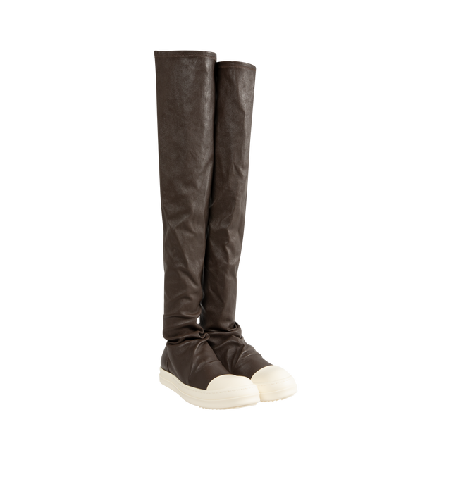 Image 1 of 5 - BROWN - Rick Owens Women's High Stocking Sneakers are crafted from stretch lamb leather and feature an above-the-knee silhouette, draped stocking-style uppers, toe caps, and the brand's signature shark-toothed bumper soles. Designed with a flexible stretch construction created by bonding leather to a cotton and Lycra backing, this statement style combines sculptural proportions with a secure, body-contouring fit. Main Material: 65% Lamb Leather, 34% Cotton, 1% Spandex. Toe: 100% Calf Leather.