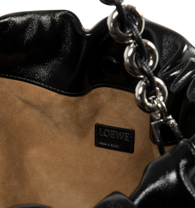 Image 4 of 4 - BLACK - LOEWE Large Flamenco Purse in patent nappa lambskin featuring a ruched shape, historical knot drawstrings, detachable donut chain, shoulder, crossbody or hand carry, detachable and adjustable leather strap, magnetic closure, suede lining and silver embossed LOEWE. Patent nappa lambskin. 26 cm x 41 cm x 9 cm. Made in Spain.