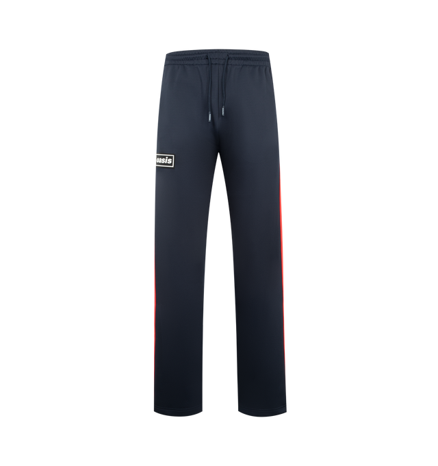 Image 1 of 3 - NAVY - PLEASURES Forever Track Pants featuring drawstring waistband, 3-pocket styling, rubberized front logo, straight leg and midweight pique fabric. 94% polyester, 6% spandex.