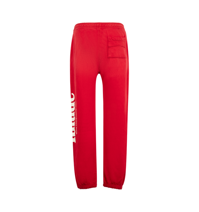 Image 2 of 4 - RED - Rhude Desert Racing Script Cuffed Sweatpant is crafted from cotton and features a relaxed silhouette with elasticated cuffs for a tapered fit. Designed with Desert Racing Script graphics, an elasticated waistband, and functional pocket detailing for everyday comfort. Main Material: 100% Cotton. Made in USA.