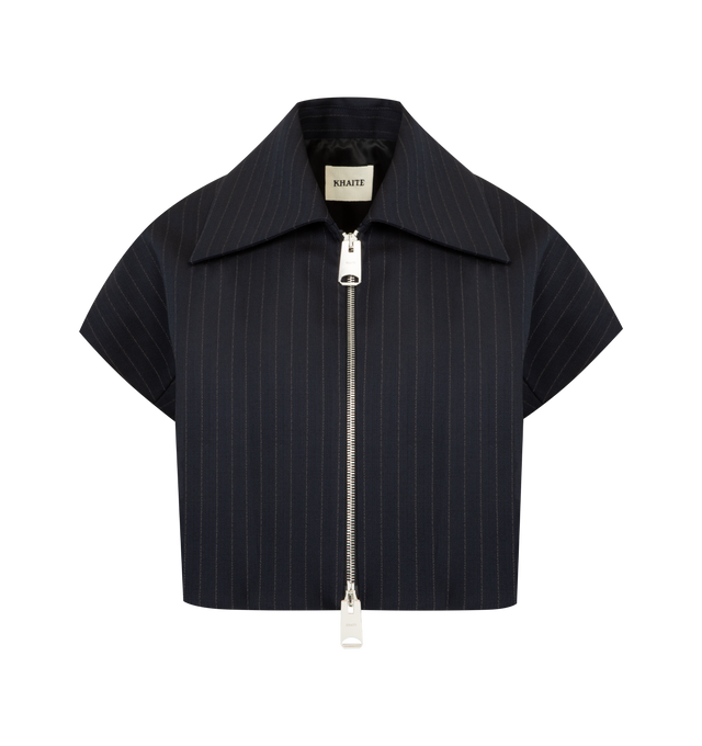 Image 1 of 2 - NAVY - KHAITE Robin Top featuring a rounded, gently cropped silhouette that is part top and part jacket, tailored in chalk-striped suiting, cap sleeves and bold, two-way zipper. 96% virgin wool, 2% elastane, 2% cotton.