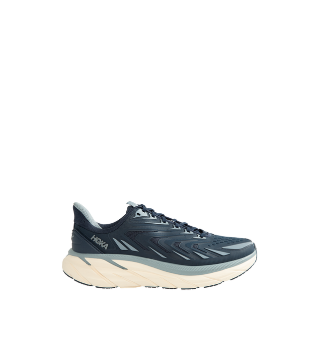 Image 1 of 5 - BLUE - Hoka Men's Clifton UTL is crafted with a breathable mesh upper and features raised PU-molded overlays that create a textured exoskeleton for added durability and support. Built on the brands popular Clifton 8 platform, this lifestyle sneaker is designed with reflective laces and webbing details, a plush CMEVA midsole, and a Durabrasion rubber outsole for everyday comfort and traction. Upper: Mesh with PU-Molded Overlays. Midsole: CMEVA. Outsole: Durabrasion Rubber. Details: Reflective