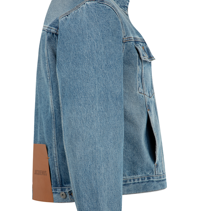 Image 3 of 3 - BLUE - JACQUEMUS Denim Jacket featuring straight cut, washed indigo denim, pointed collar, engraved metal buttons, denim patch pockets, buttoned cuffs, front and back yoke, buttoned tab on the back hem, silver hardware, large denim patch and contrast stitching. 100% cotton. Made in Portugal.