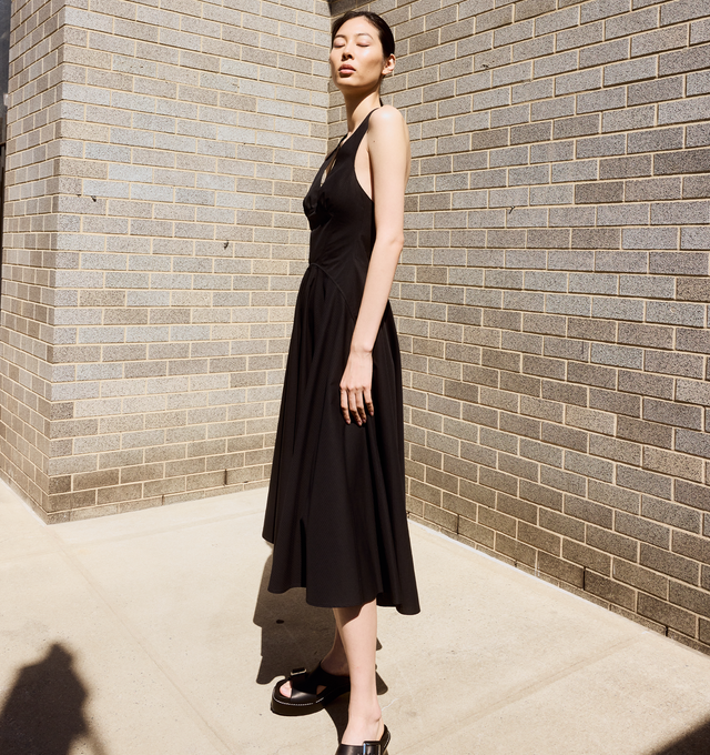 Image 3 of 4 - BLACK - Alaia V-Neck Sleeveless Crossback Cotton Midi Dress fetauring a crossover strappy low back, deep V neckline, fit-and-flare silhouette, below-the-knee length, invisible back zip. Made in Italy. 