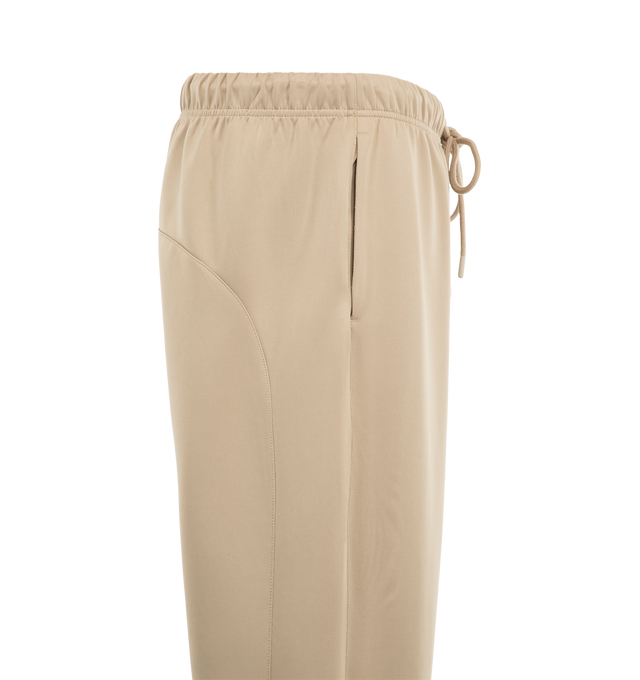 Image 3 of 4 - NEUTRAL - Fear of God ESSENTIALS Men's Classic Trackpant is crafted from heavyweight cotton-blend fleece and features a slim straight-leg silhouette with side-seam detailing and adjustable closure. Designed to provide structure and comfort, this elevated essential is finished with an encased elastic waistband, elongated drawcords, side-seam pockets, and an updated Fear of God Essentials label at the center front. Main Material: 80% Cotton, 20% Polyester Fleece, 380 GSM. Imported.