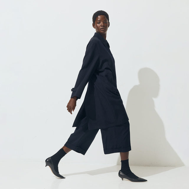 woman wearing navy car coat and wide leg cropped pants by The Row 