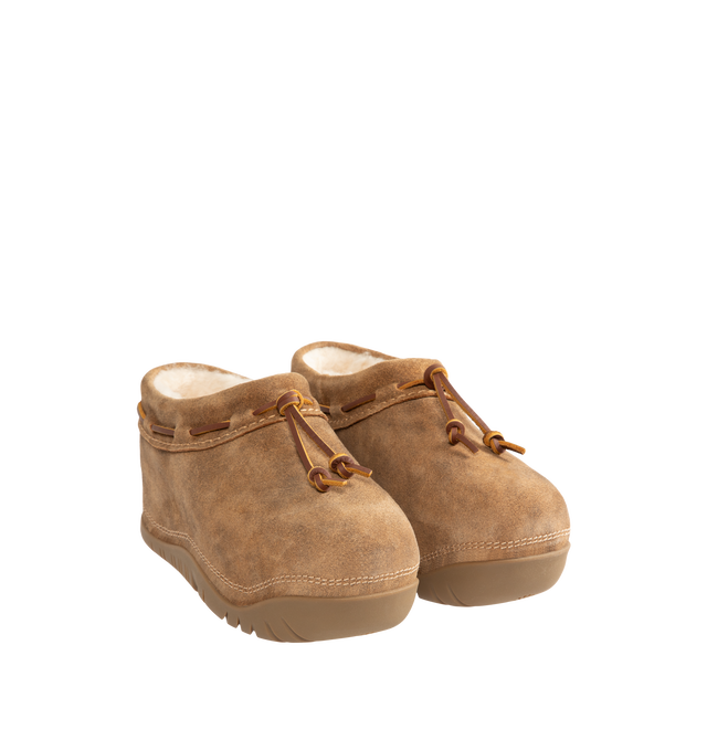 Image 2 of 4 - BROWN - UGG women's bucked clog made in soft suede with an elevated, worn-in feel and a leather whipstitch detail, signature sheepskin lining and cushy rubber platform sole. Features sugarcane EVA midsole, molded rubber outsole, woven label with UGG Logo on insole and UGG Logo embossed suede heel label. 