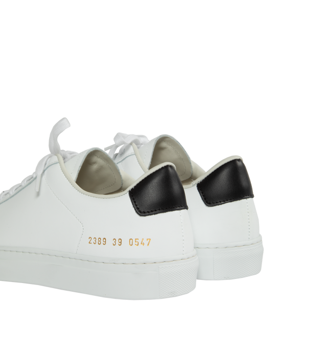 Image 3 of 5 - WHITE - Common Projects  Retro Classic Leather Lace-Up Sneakers in a minimal design crafted from white calf leather with black leather tabs at the heels, detailed with signature gold stamped serial numbers. 