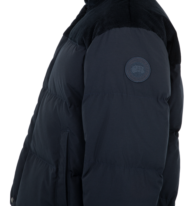 Image 4 of 4 - NAVY - Canada Goose Men's Sterling Puffer Jacket is crafted from Arctic Tech fabric and features a puffer silhouette with contrasting cotton corduroy at the shoulders and collar for a Western-inspired look. Designed with a concealed snap placket over a front zipper, an exposed bottom snap, an adjustable drawcord hem, and recessed rib-knit cuffs to help retain warmth. Main Material: Arctic Tech. Contrast: Cotton Corduroy. Closure: Hidden Snap Placket with Front Zip. Pockets: Two Snap-Welt Exte 