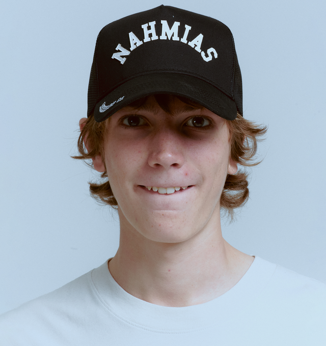 Image 2 of 3 - BLACK - NAHMIAS Summerland Brim Trucker Hat featuring a patchwork Nahmias logo on the face, mesh back and adjustable fit. 57% cotton, 43% nylon. 