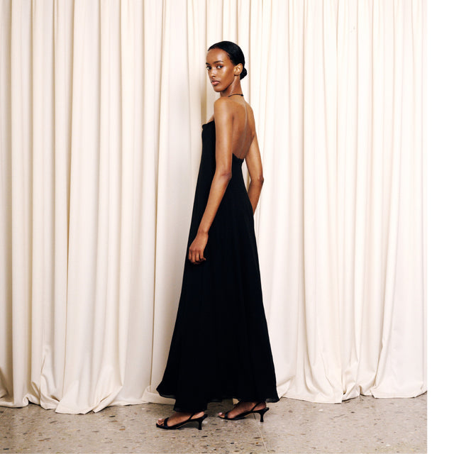 Image 3 of 4 - BLACK - The Row Women's Javier Dress is crafted from lightweight silk georgette and features a bias-cut silhouette with a fitted waist, flared hem, and a squared neckline accented by a slim halter strap. This designer silk dress combines exceptional Italian craftsmanship with an airy, fluid drape, creating an effortlessly elegant silhouette for day-to-evening occasions. Main Material: 100% Silk. Made in Italy. 